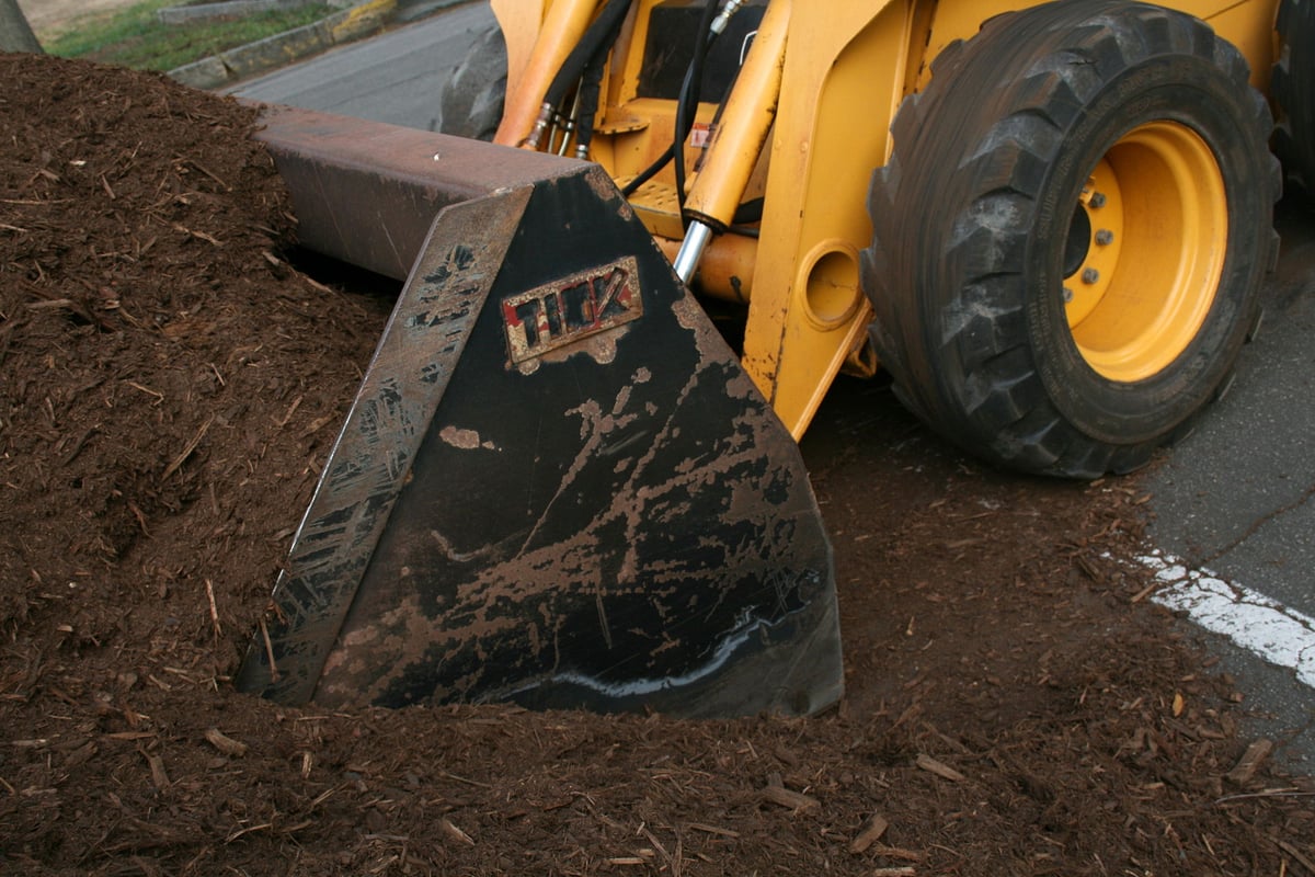 mulch being picked up by skid loader