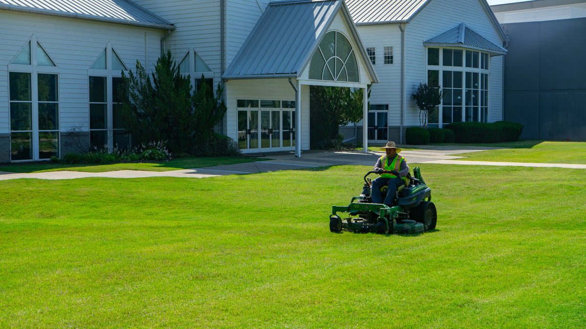 maintenance technician mows lawn at church