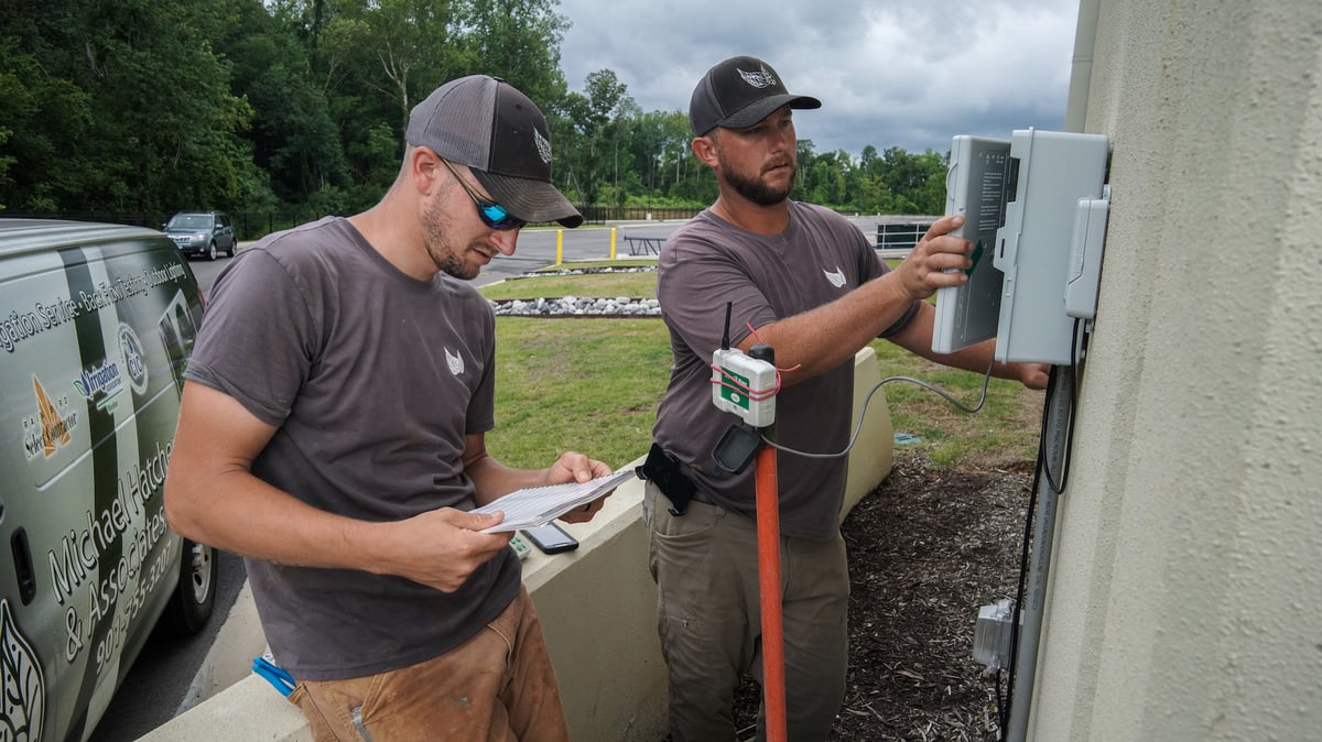 Irrigation team adjust sprinkler controller