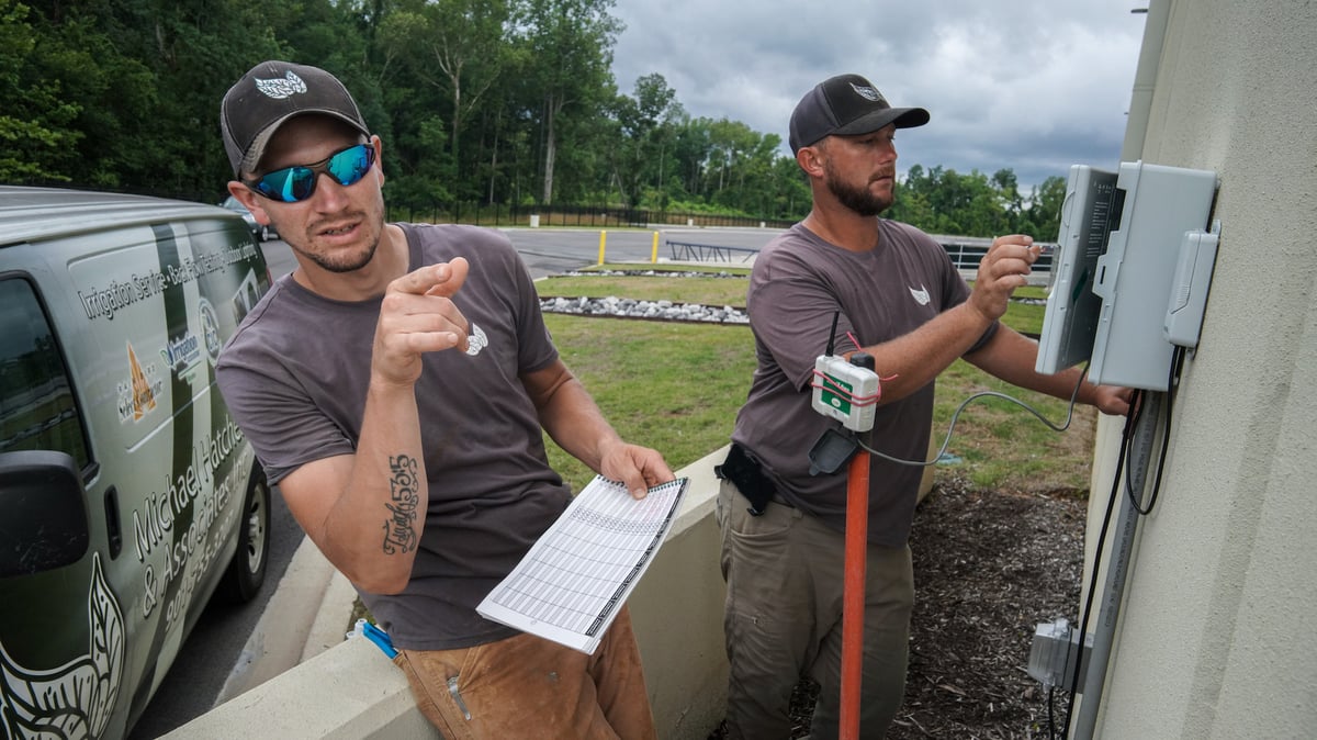 irrigation crew inspects and adjusts irrigation controller