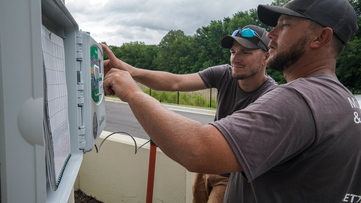 irrigation crew adjusting irrigation system controller