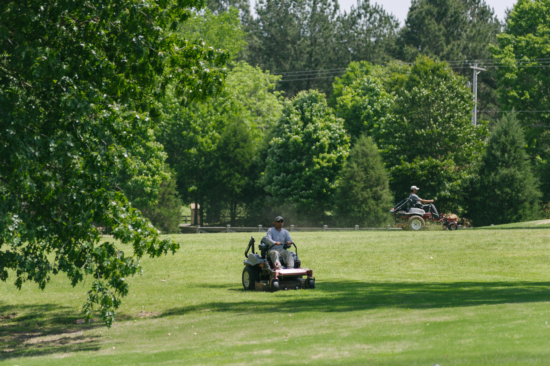 Professional landscape technician mowing commercial property