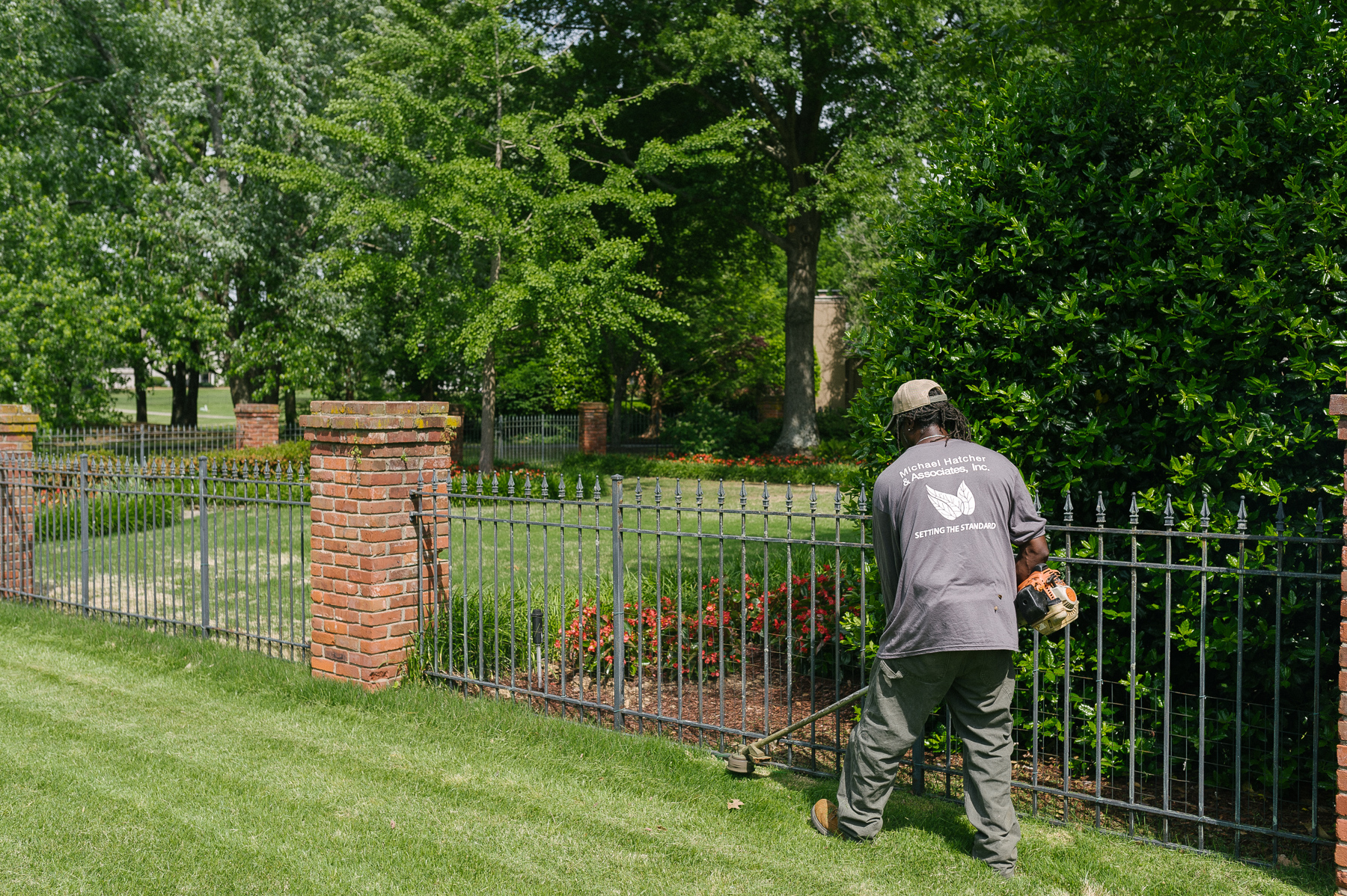 Technician trimming along fence